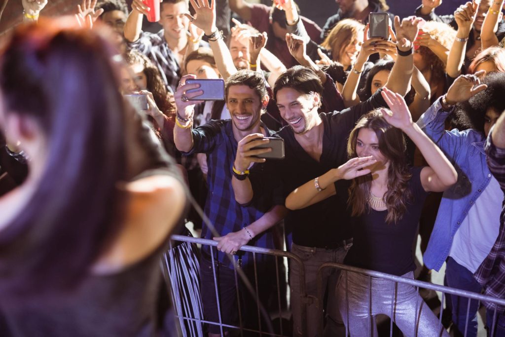 a group of cheerful music fans watching a performer
